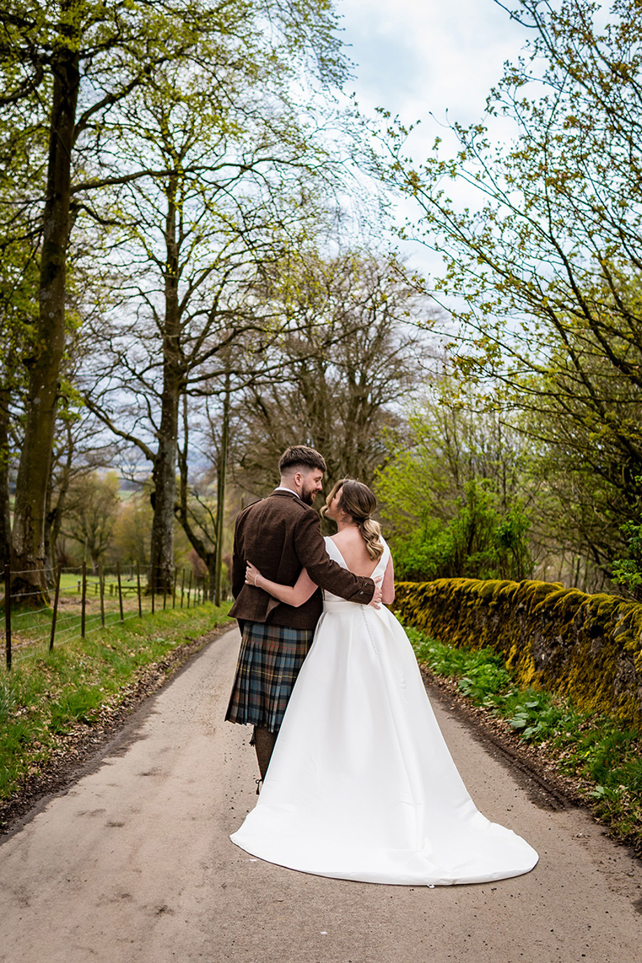 View of the back of bride and groom smiling at each other